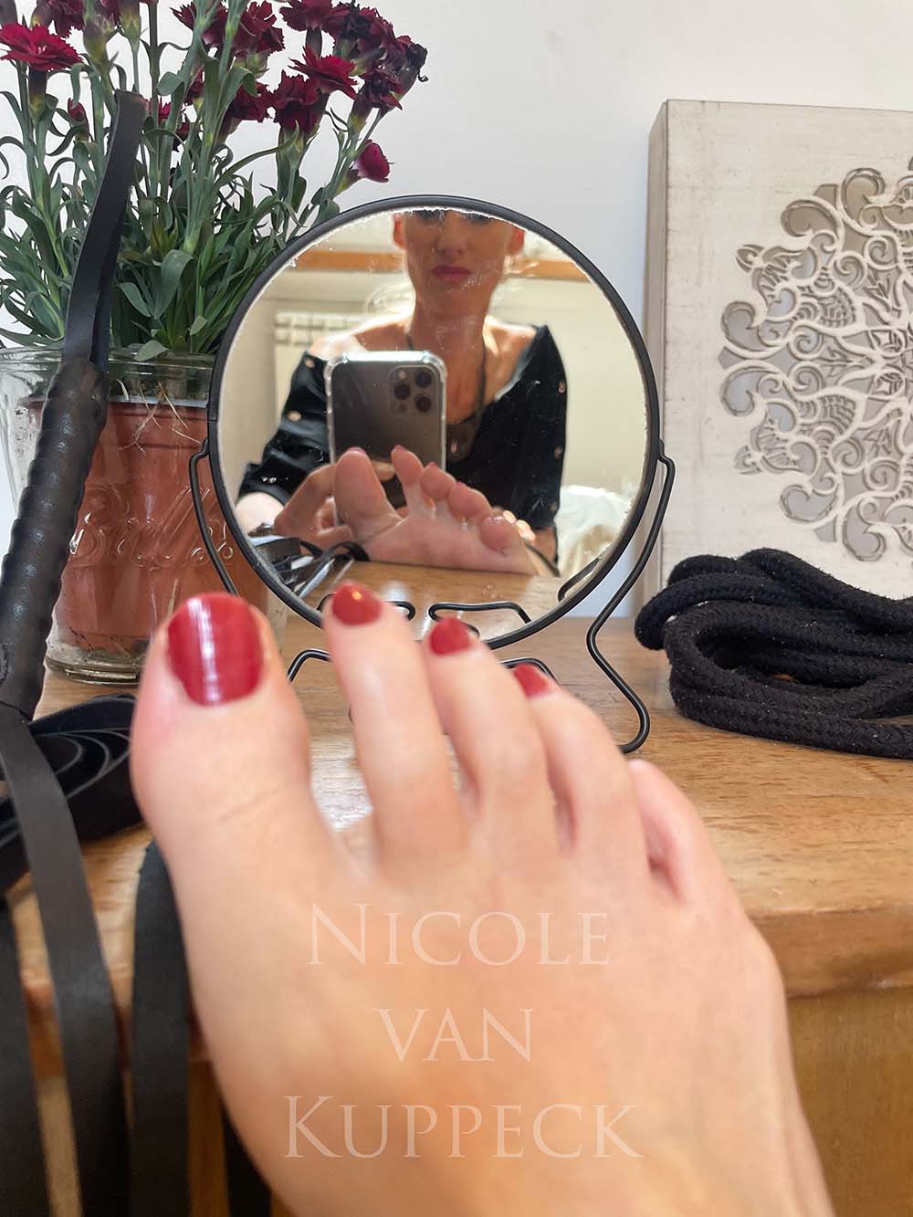 Dominatrix feet, sexy red nail polish and soles in the mirror
